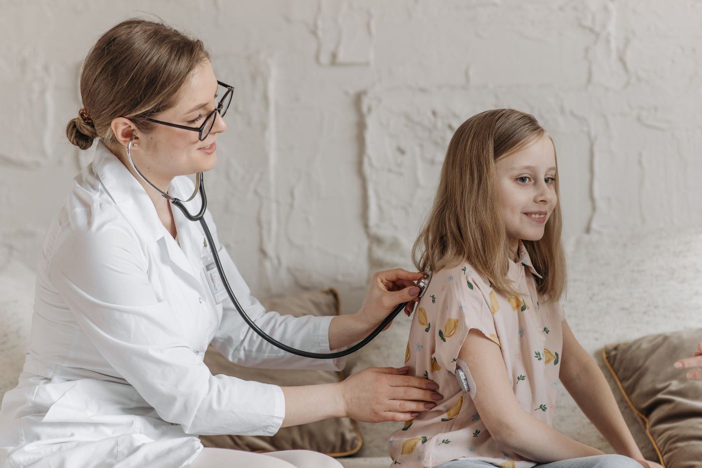 Pediatra examinando uma menina com estetoscópio